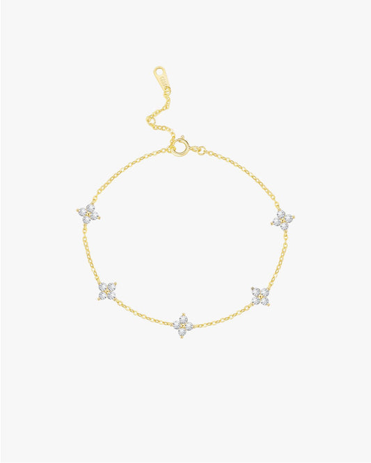 Gold bracelet with star-shaped charms on a light gray background