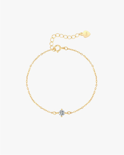 Gold chain bracelet with a central diamond flower pendant, adjustable clasp, and heart-shaped tag. Elegant jewelry accessory for women.