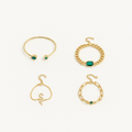 Gold bracelets set with green gemstones, featuring a cuff, chain link, and snake design, elegantly displayed on a white background.