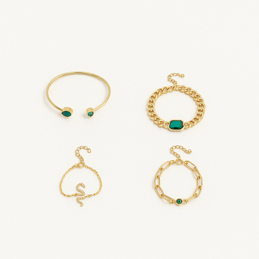 Gold bracelets set with green gemstones, featuring a cuff, chain link, and snake design, elegantly displayed on a white background.