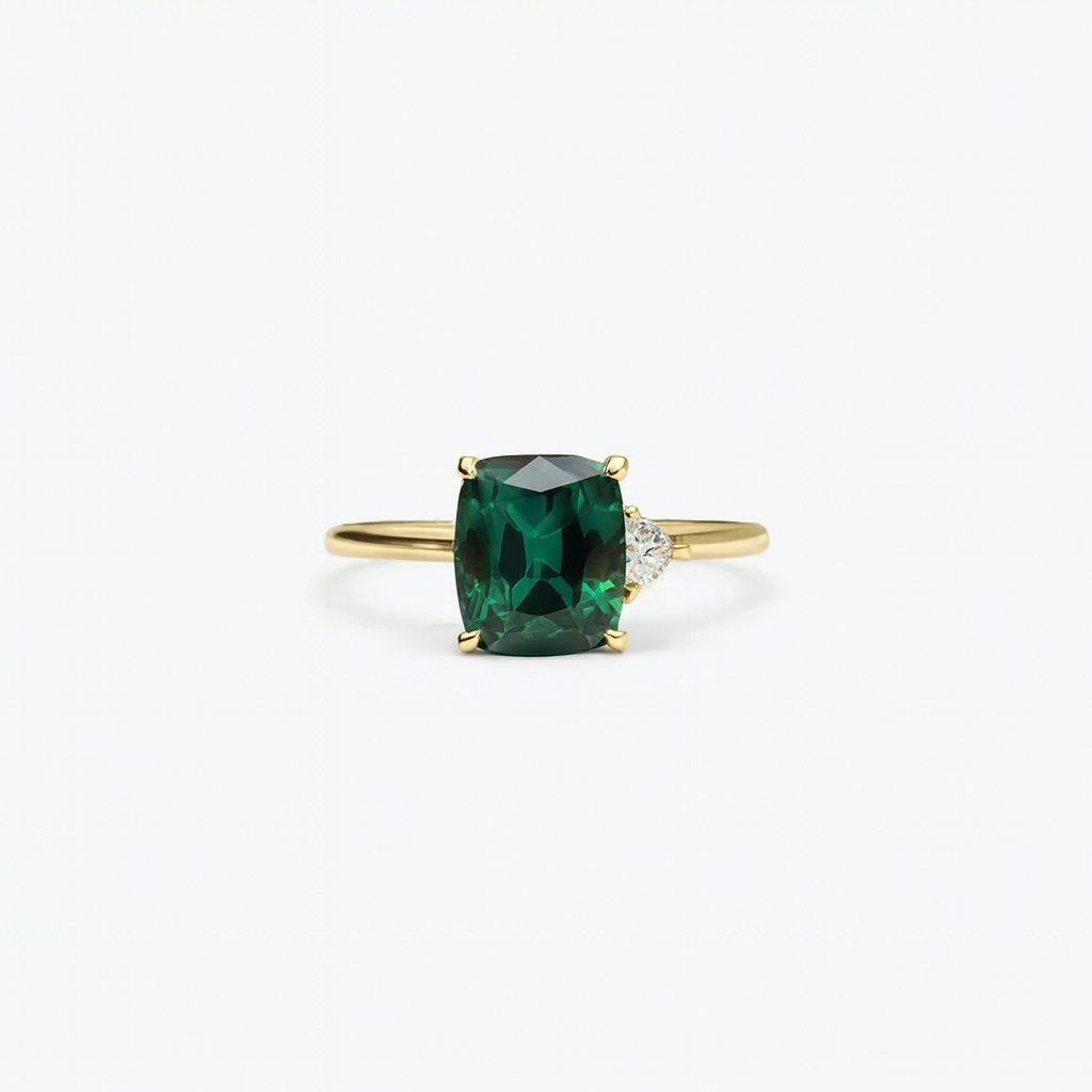 Gold ring with a cushion-cut green gemstone and a small diamond accent, elegant jewelry design, perfect for engagement or special occasions.