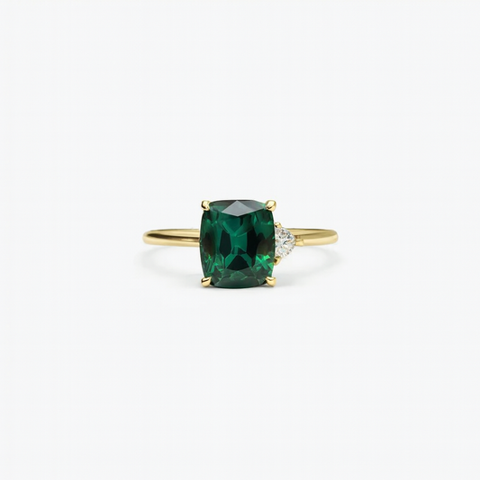 Gold ring with a cushion-cut green gemstone and a small diamond accent, elegant jewelry design, perfect for engagement or special occasions.