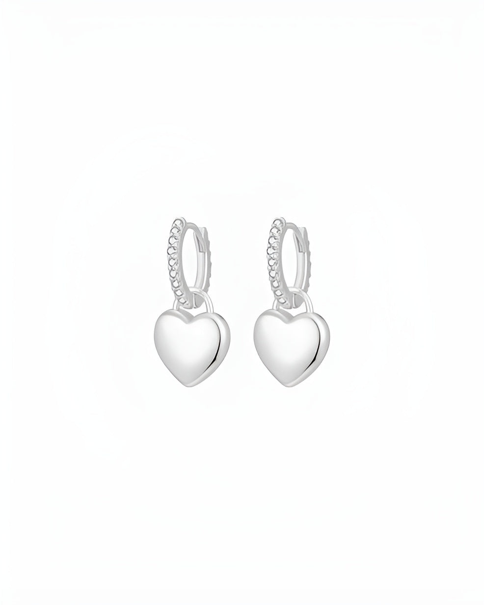 Heart-shaped silver hoop earrings on a white background
