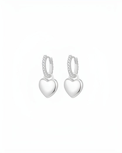 Heart-shaped silver hoop earrings on a white background