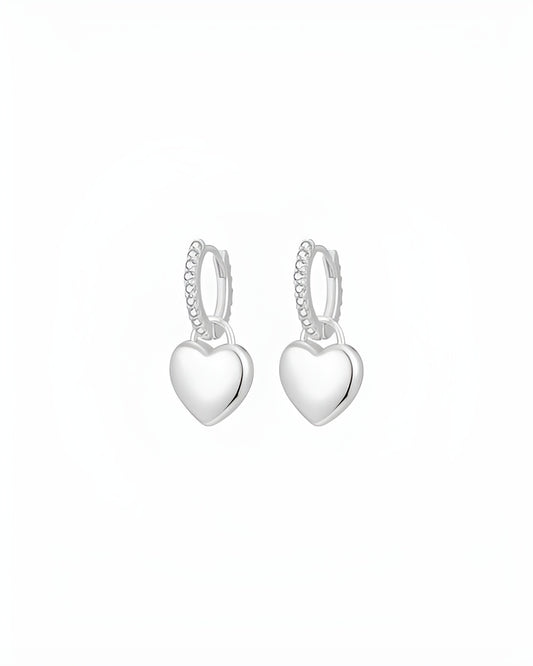 Heart-shaped silver hoop earrings on a white background