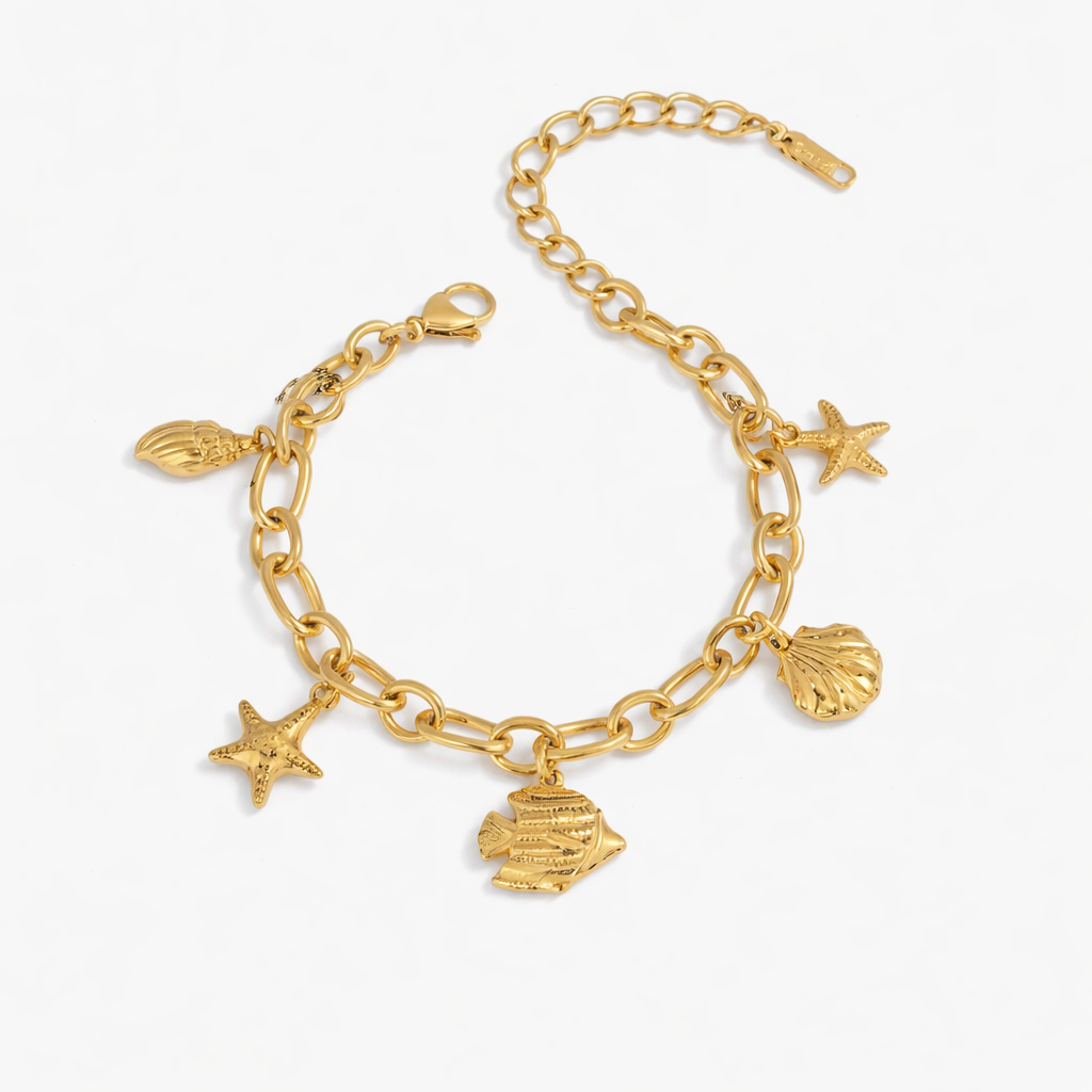 Gold bracelet with shell, starfish, and fish charms on a white background