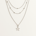 Layered silver necklaces with star pendants on a white background