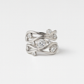Silver ring with diamond accents on a light gray background