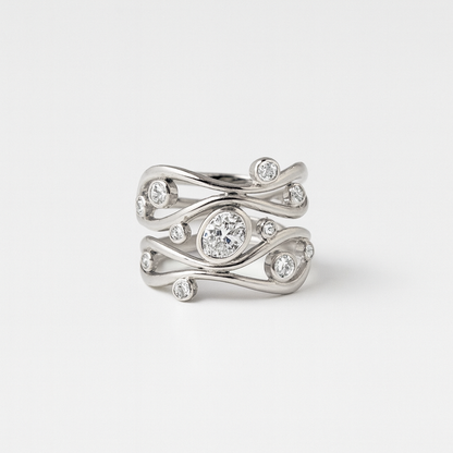 Silver ring with diamond accents on a light gray background