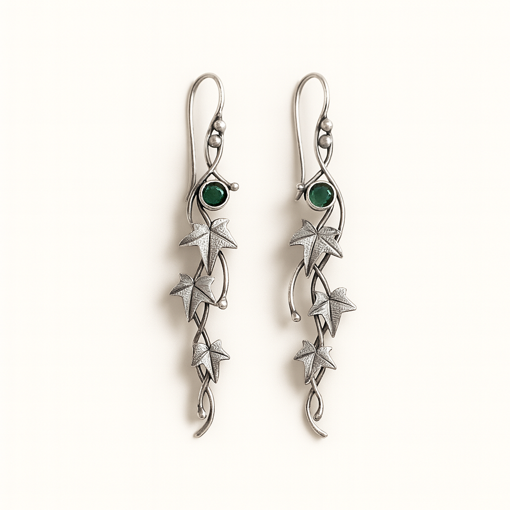 Silver earrings with green gemstones on a white background