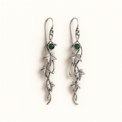 Silver earrings with green gemstones on a white background