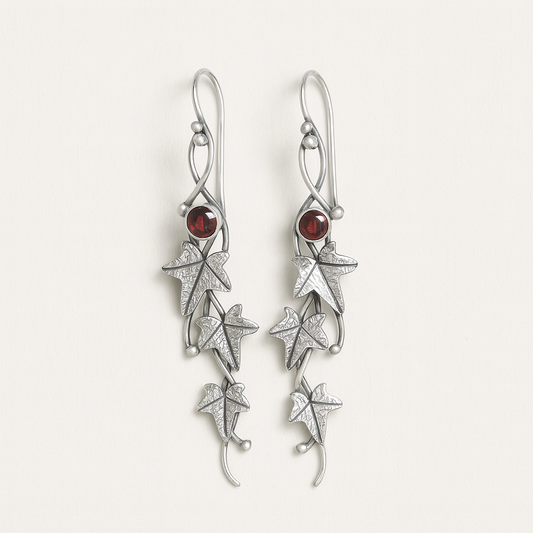 Silver earrings with star designs and red gemstones on a white background
