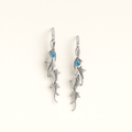 Silver earrings with blue gemstones on a white background