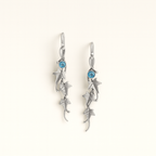Silver earrings with blue gemstones on a white background