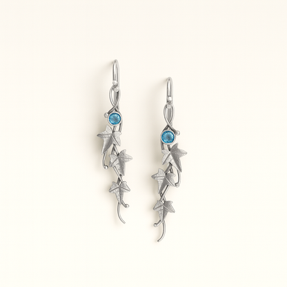 Silver earrings with blue gemstones on a white background