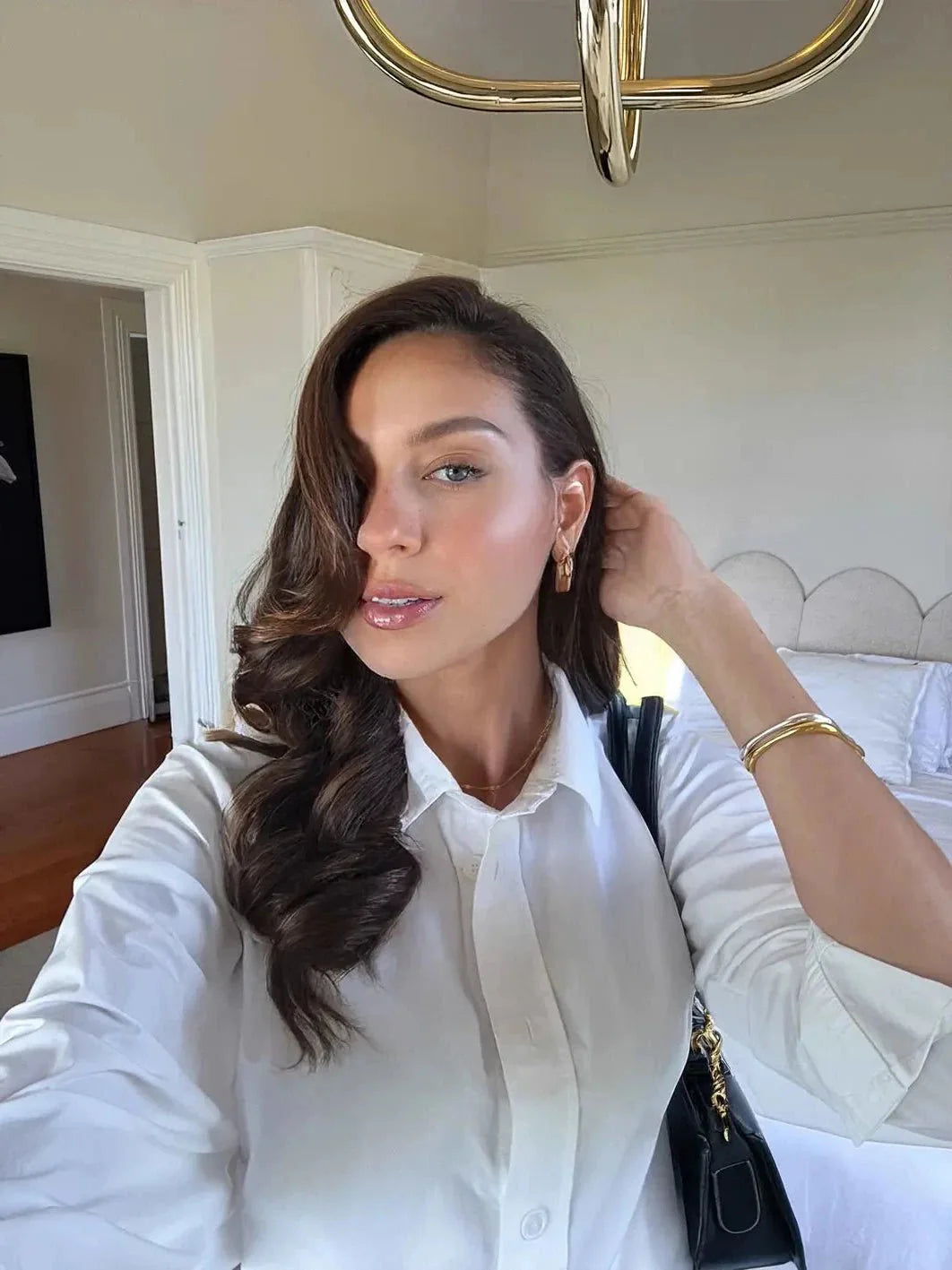 Woman in a white shirt in a bedroom setting