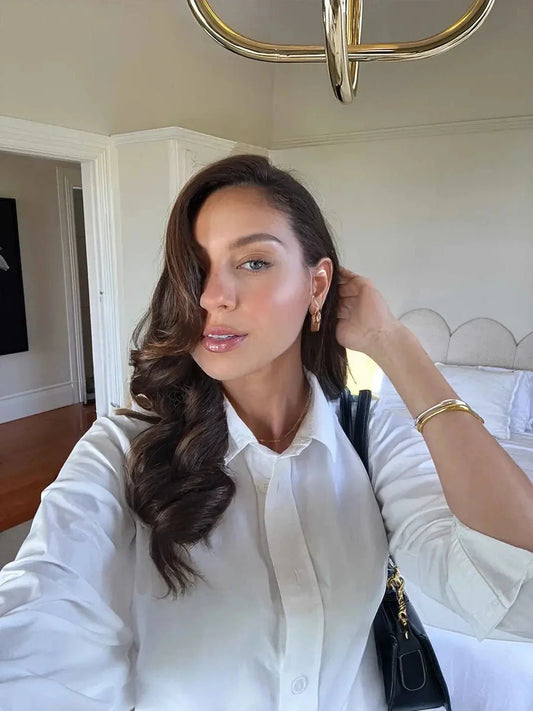 Woman in a white shirt in a bedroom setting