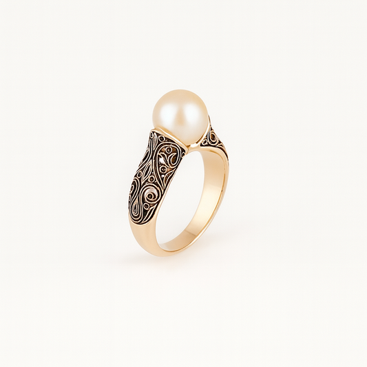 Gold ring with intricate filigree design featuring a large, lustrous pearl centerpiece. Elegant jewelry, luxury accessory, sophisticated style.