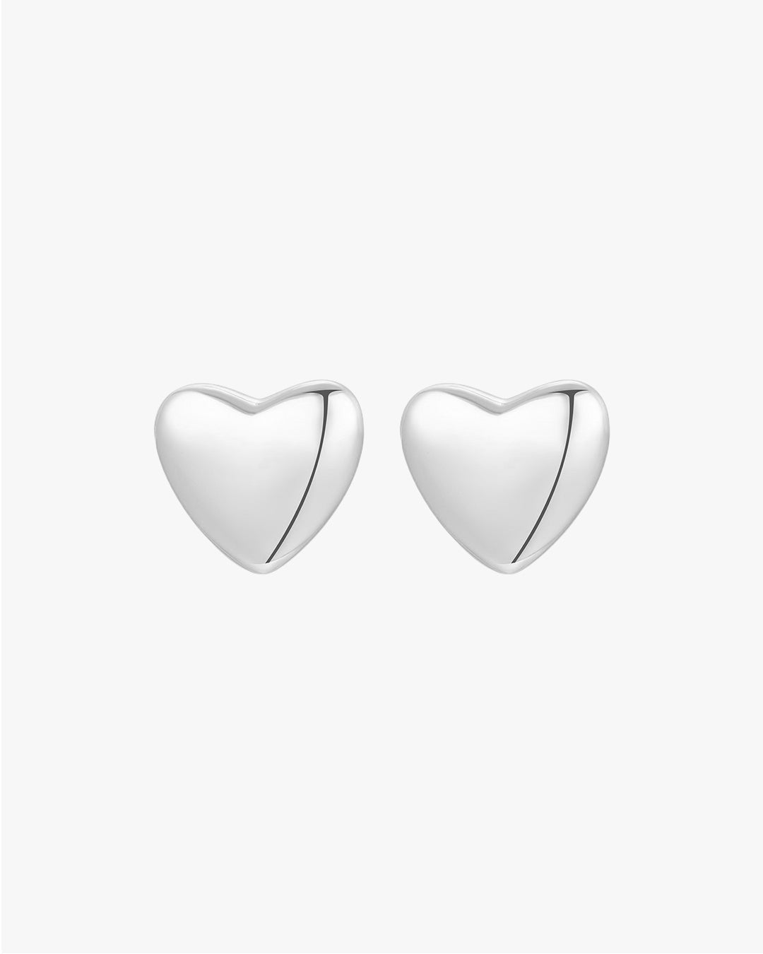 Silver heart-shaped stud earrings on a white background, minimalist jewelry design, perfect for everyday wear, elegant and timeless accessory.