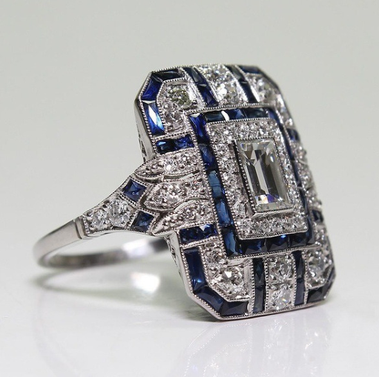 Elegant ring with blue and white gemstones on a light gray background