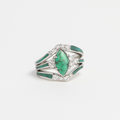 Silver ring with a large green gemstone and smaller clear stones on a white background