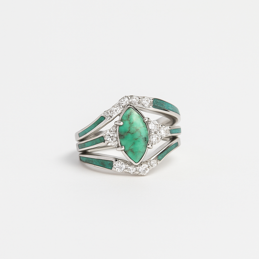 Silver ring with a large green gemstone and smaller clear stones on a white background