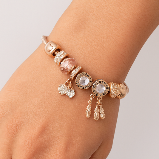 Rose gold bracelet with charms on a wrist against a neutral background
