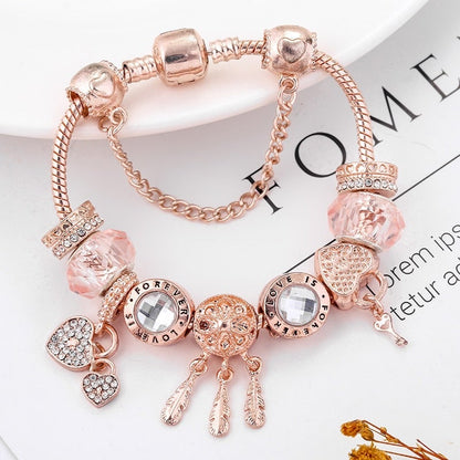 Rose gold bracelet with various charms on a magazine page background