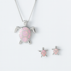 Silver turtle jewelry set with pink opal inlay, featuring a necklace and matching earrings. Elegant ocean-themed accessories for women.