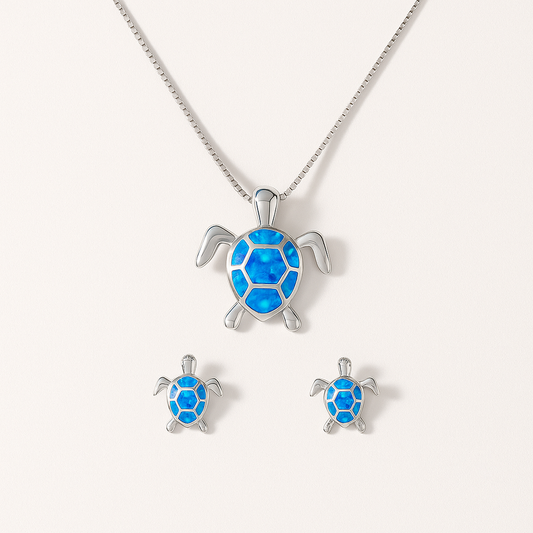Silver turtle jewelry set with blue opal inlay, featuring a necklace and matching earrings. Perfect for ocean-themed fashion and gifts.