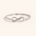 Silver infinity bracelet on a light beige background