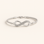 Silver infinity bracelet on a light beige background
