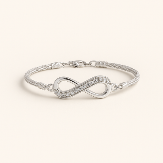 Silver infinity bracelet on a light beige background