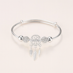 Silver dreamcatcher charm bracelet with intricate feather pendants, elegant design, perfect for boho fashion, women's jewelry accessory.