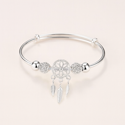 Silver dreamcatcher charm bracelet with intricate feather pendants, elegant design, perfect for boho fashion, women's jewelry accessory.