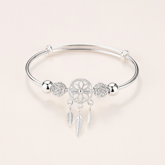 Silver dreamcatcher charm bracelet with intricate feather pendants, elegant design, perfect for boho fashion, women's jewelry accessory.
