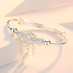 Silver dreamcatcher bracelet with intricate bead and feather charms, elegant jewelry accessory, perfect for boho fashion and gift ideas.