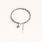 Silver bracelet with a heart charm on a white background