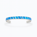 Silver cuff bracelet with vibrant blue opal inlay, geometric design. Elegant jewelry accessory, perfect for fashion-forward style.