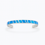Silver cuff bracelet with vibrant blue opal inlay, geometric design. Elegant jewelry accessory, perfect for fashion-forward style.