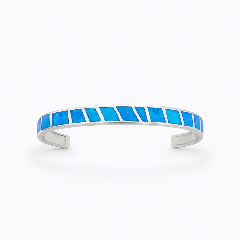 Silver cuff bracelet with vibrant blue opal inlay, geometric design. Elegant jewelry accessory, perfect for fashion-forward style.