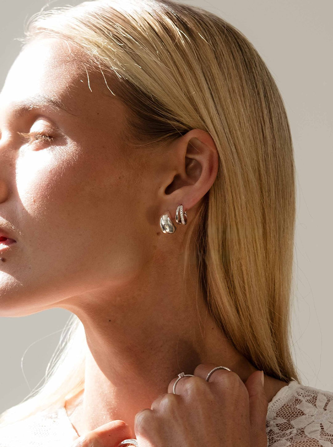 Close-up of a woman wearing earrings with a neutral background