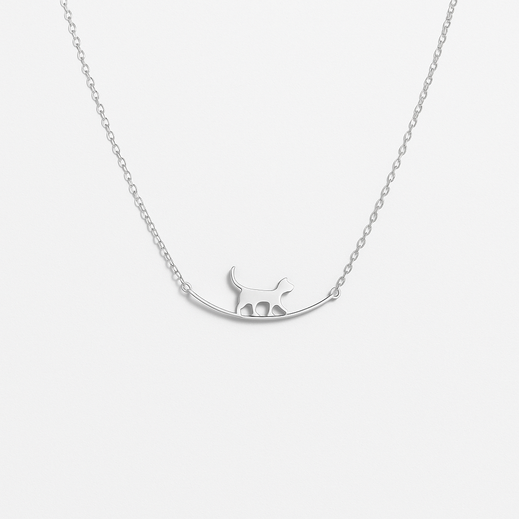 Silver cat pendant necklace on delicate chain, minimalist jewelry design, perfect for cat lovers, elegant accessory for everyday wear.