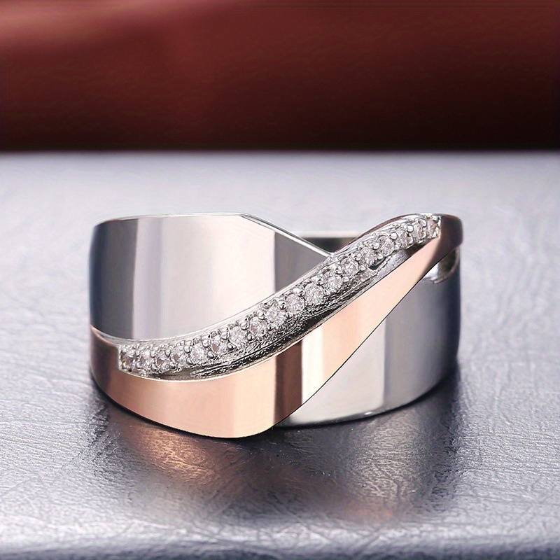 Elegant silver and rose gold ring with diamond accents, featuring a modern wave design. Perfect for weddings, engagements, or luxury fashion.