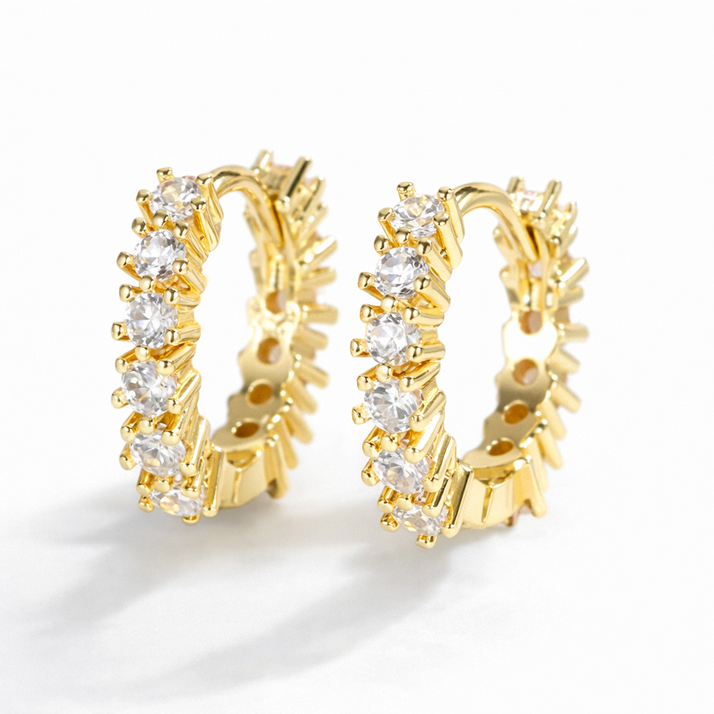 Gold hoop earrings with clear gemstones on a white background