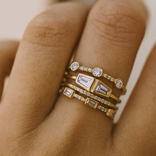 Gold rings with gemstones on a person's finger