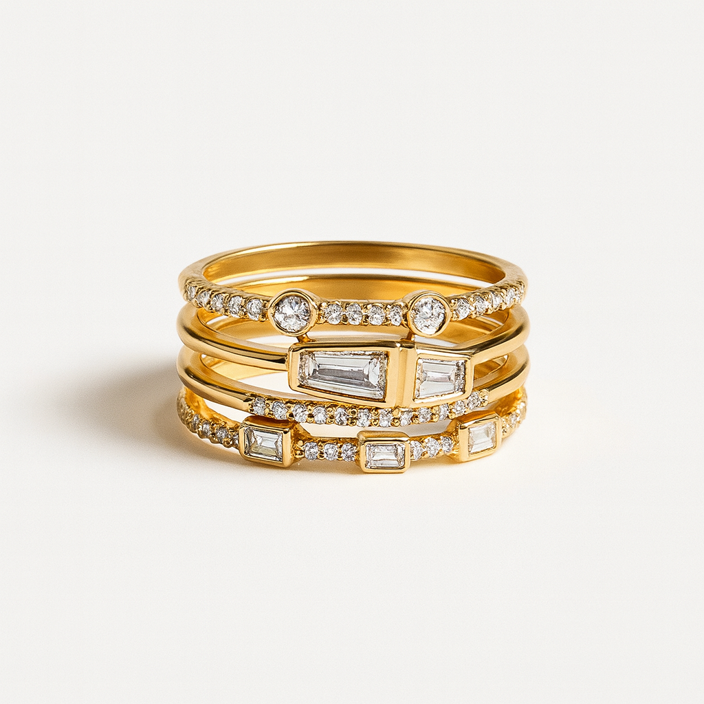 Stack of gold rings with diamond accents on a light background