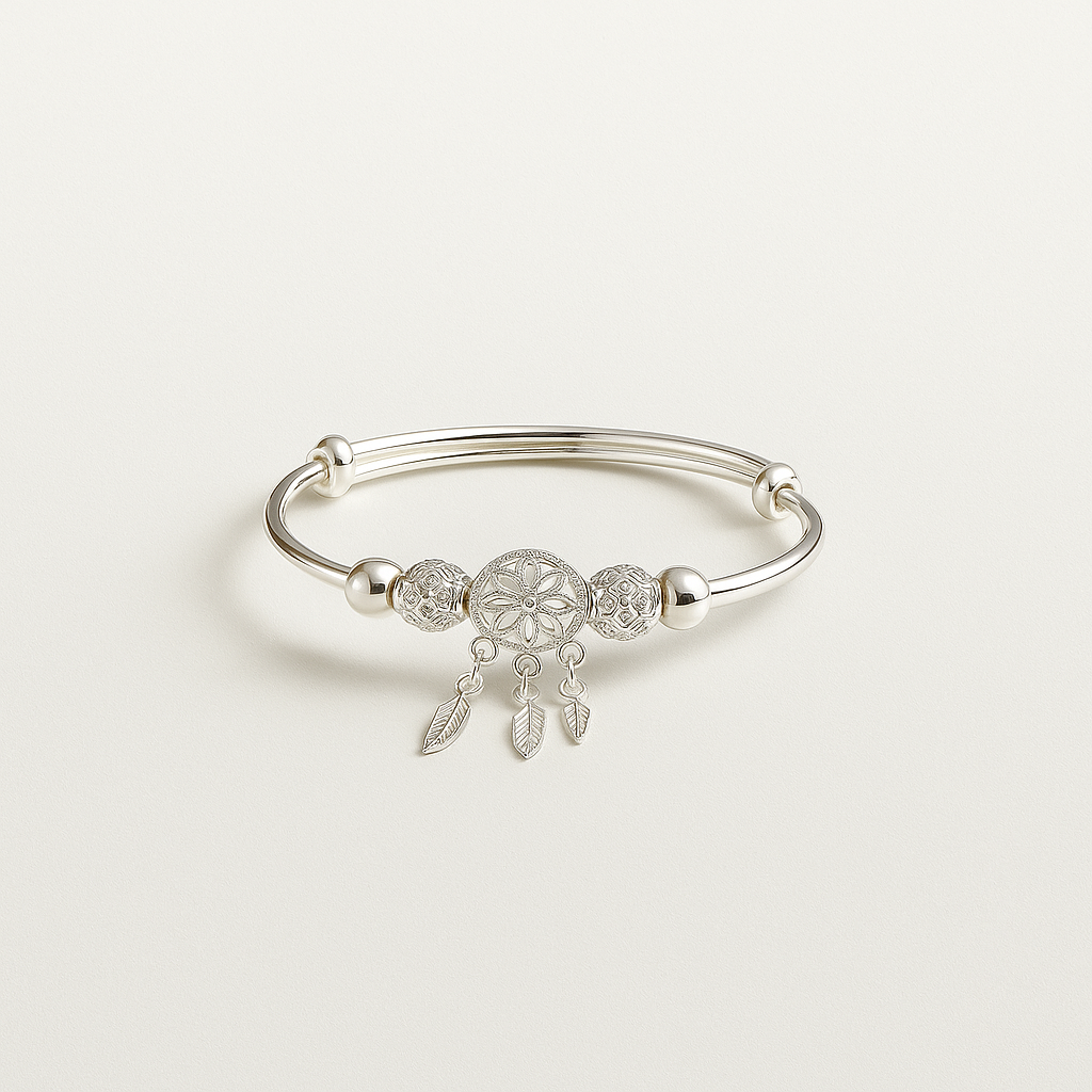Silver bracelet with a dreamcatcher charm on a light gray background