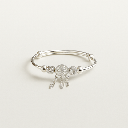 Silver bracelet with a dreamcatcher charm on a light gray background
