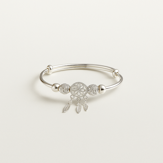 Silver bracelet with a dreamcatcher charm on a light gray background